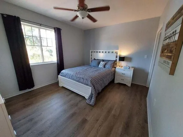 a bedroom with a bed and wooden floor