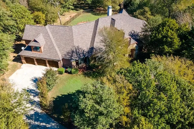 an aerial view of a house with swimming pool and garden
