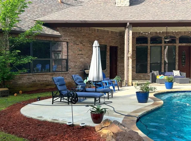 a view of a house with backyard sitting area and garden