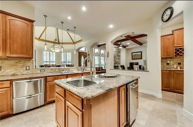 a kitchen with stainless steel appliances granite countertop a sink a stove and a refrigerator