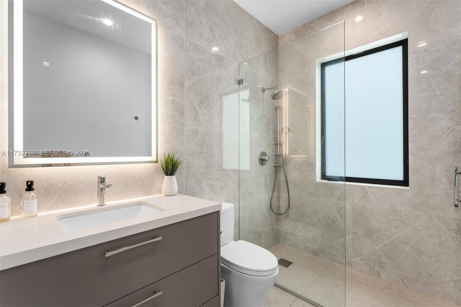 13180 Old Cutler Road Pinecrest, FL 33156 - Photo 22 of 66 a bathroom with a sink toilet and shower