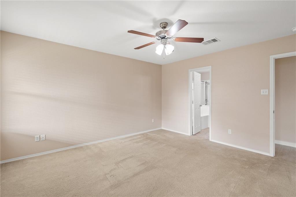 20224 Merlin Falcon Trail Pflugerville, TX 78660 - Photo 28 of 40 A spacious bedroom offers comfort with soft carpet and a convenient en-suite bathroom access.