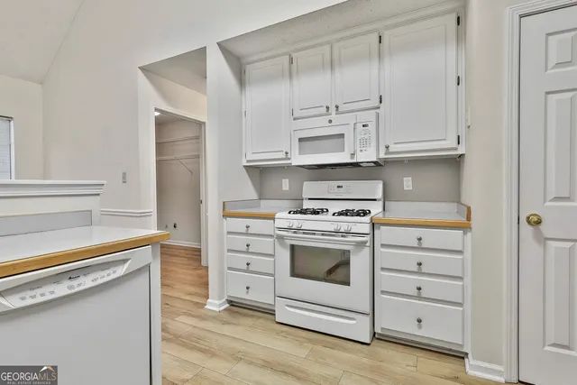 a kitchen with cabinets appliances and a wooden floor