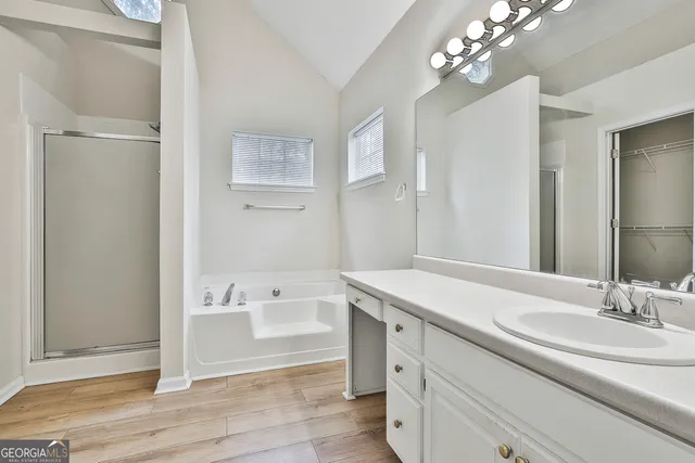 a spacious bathroom with a granite countertop sink a large mirror and a shower