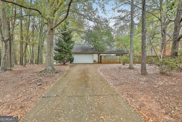 a view of a house with backyard and a tree
