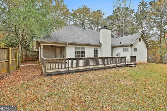 a view of a house with a fence and a yard