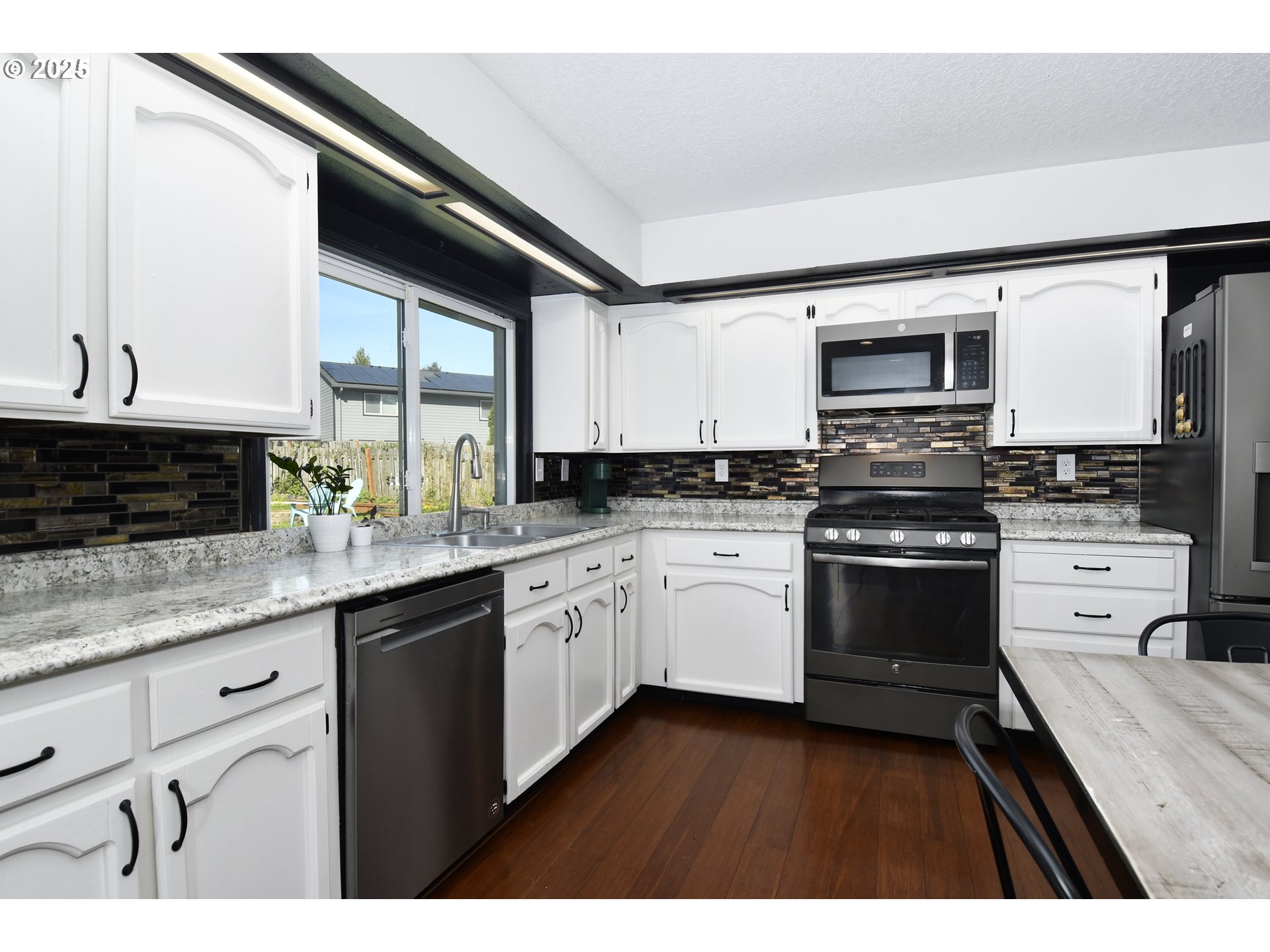 5013 Southeast 22nd Street Gresham, OR 97080 - Photo 9 of 38 a kitchen with stainless steel appliances granite countertop a stove sink microwave and cabinets