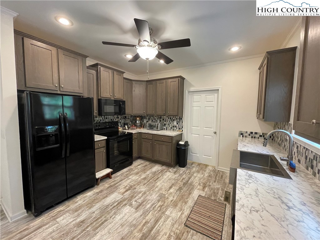 227 Meadow Pines Trail Boone, NC 28607 - Photo 21 of 34 a kitchen with stainless steel appliances kitchen island granite countertop a refrigerator a sink dishwasher a stove and white cabinets with wooden floor