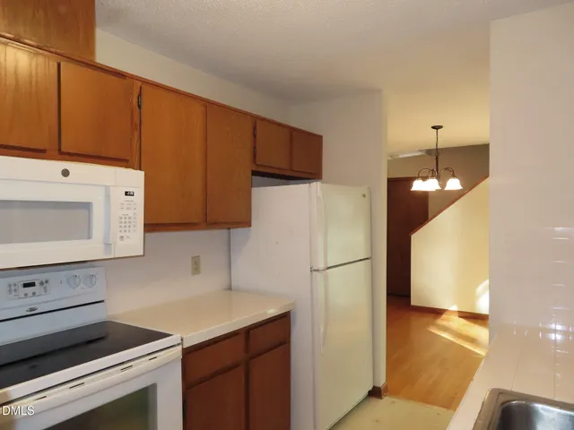 a kitchen with a refrigerator sink and cabinets