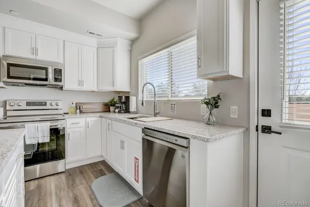 a bathroom with a granite countertop toilet sink and mirror