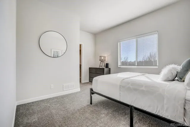 a bedroom with a bed and a mirror