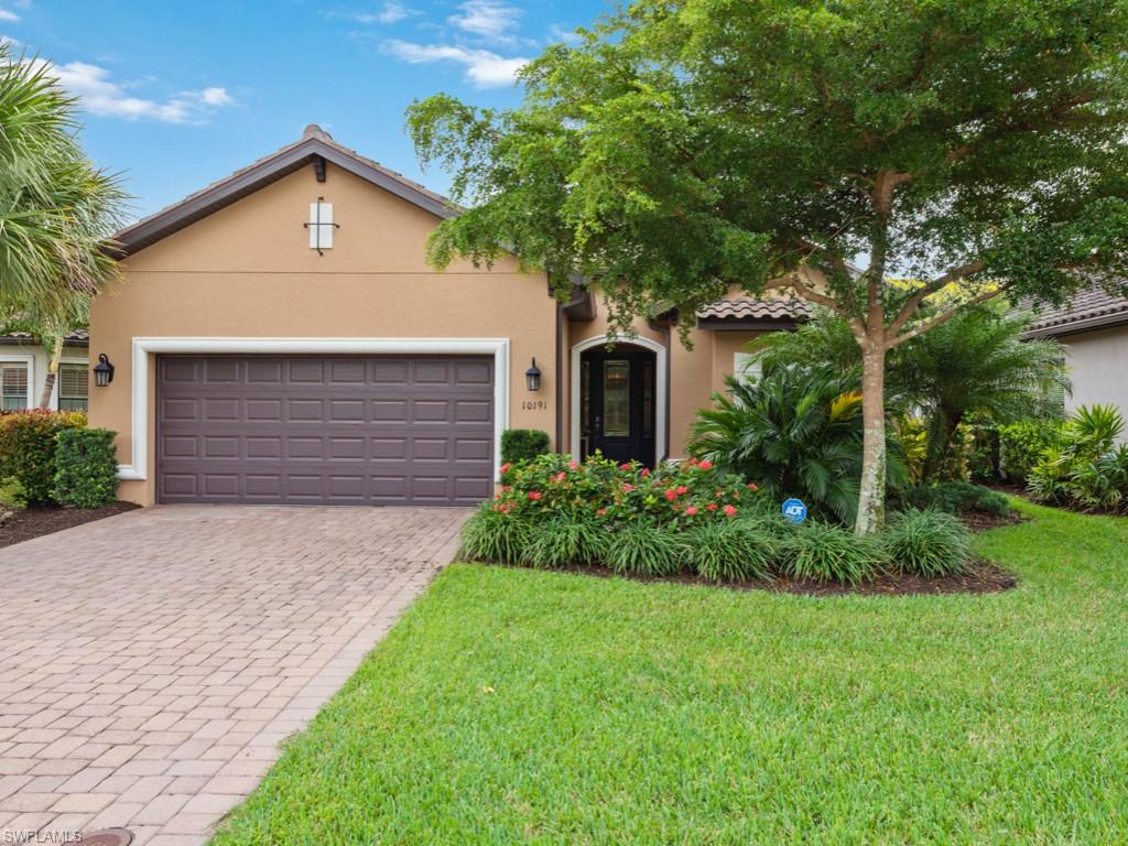 10191 Coconut Road Estero, FL 34135 - Photo 1 of 14 a front view of a house with a garden and plants