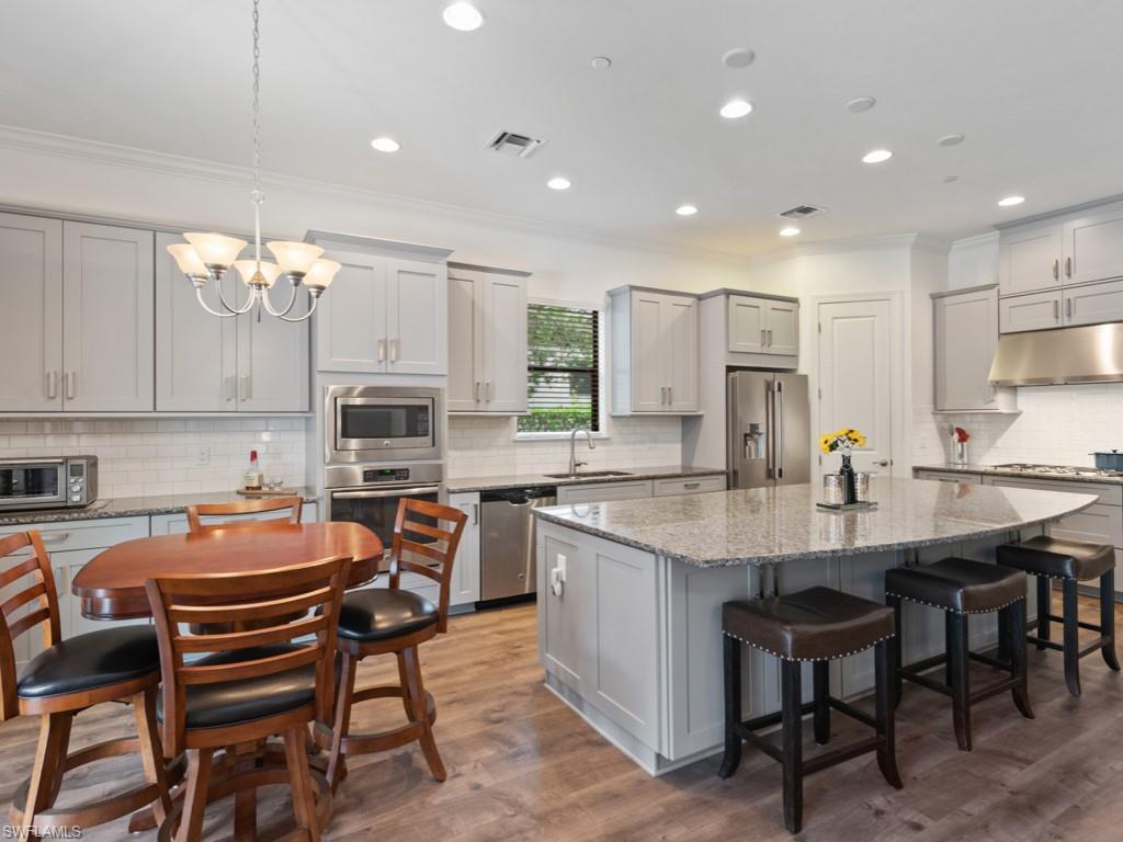 10191 Coconut Road Estero, FL 34135 - Photo 3 of 14 a kitchen with a table chairs sink and cabinets