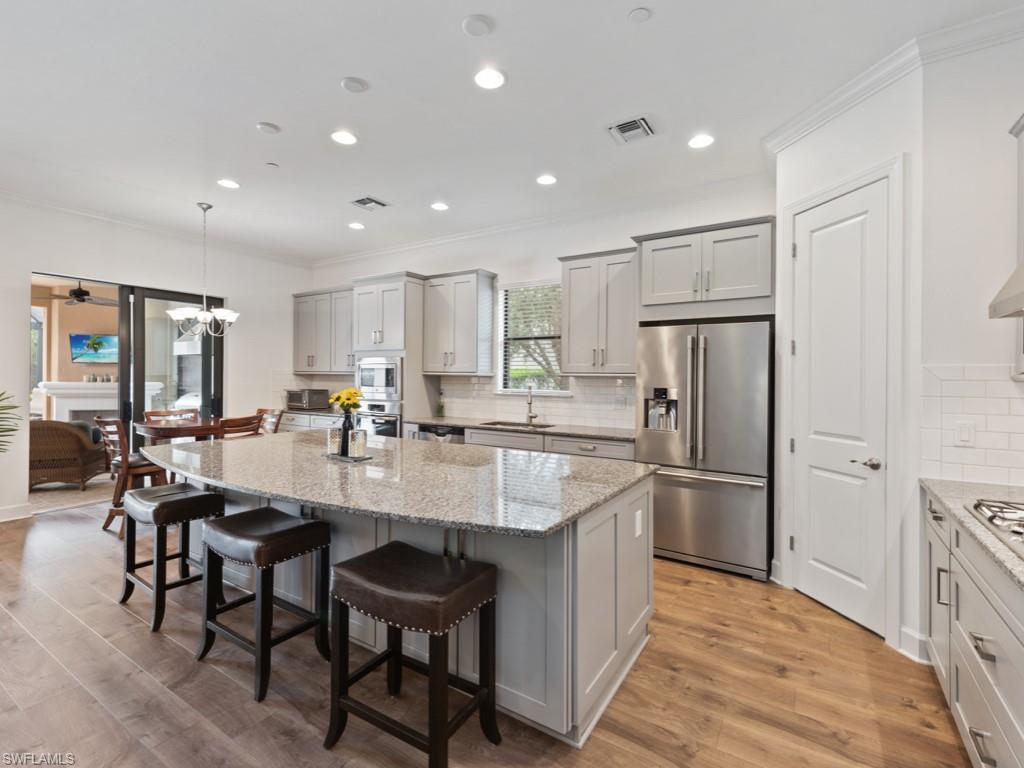 10191 Coconut Road Estero, FL 34135 - Photo 4 of 14 a large kitchen with kitchen island a table and chairs