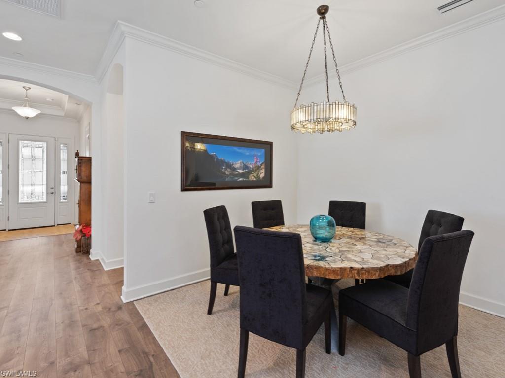 10191 Coconut Road Estero, FL 34135 - Photo 5 of 14 a view of a dining room with furniture wooden floor and a chandelier