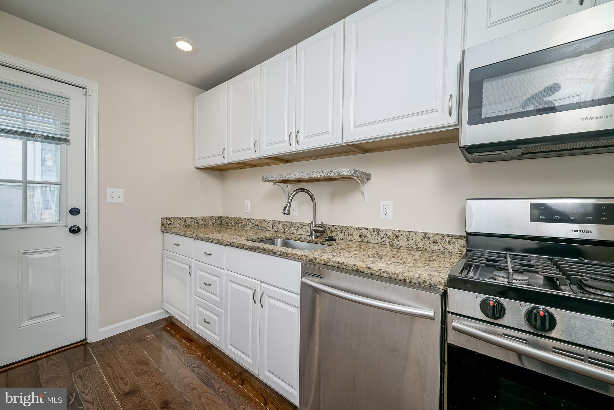 816 Maple Avenue Laurel, MD 20707 - Photo 16 of 45 a kitchen with stainless steel appliances granite countertop a stove a sink and white cabinets