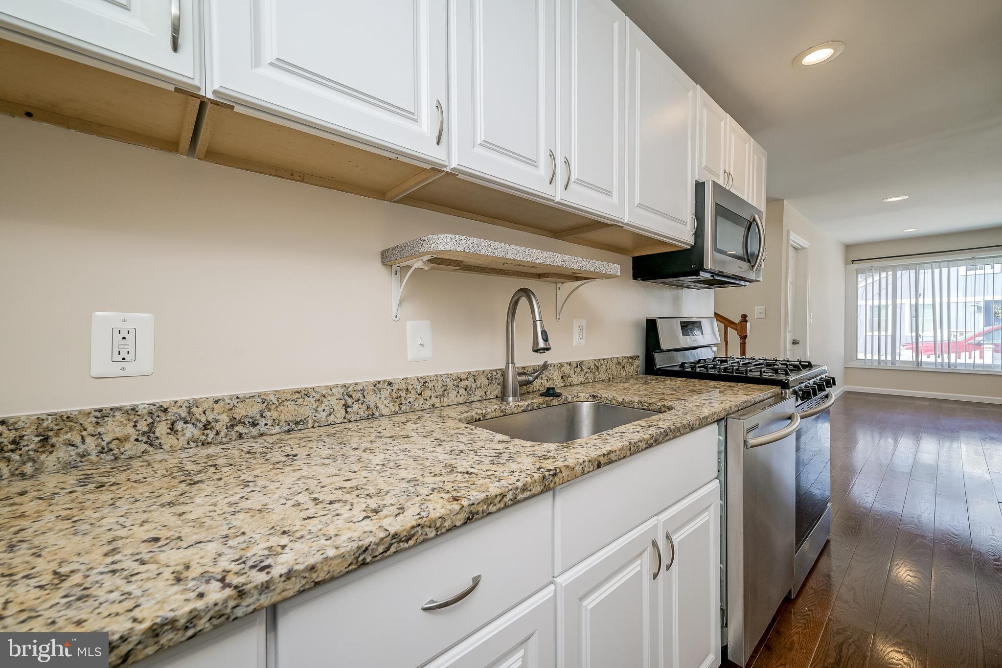 816 Maple Avenue Laurel, MD 20707 - Photo 17 of 45 a kitchen with granite countertop a sink and a stove