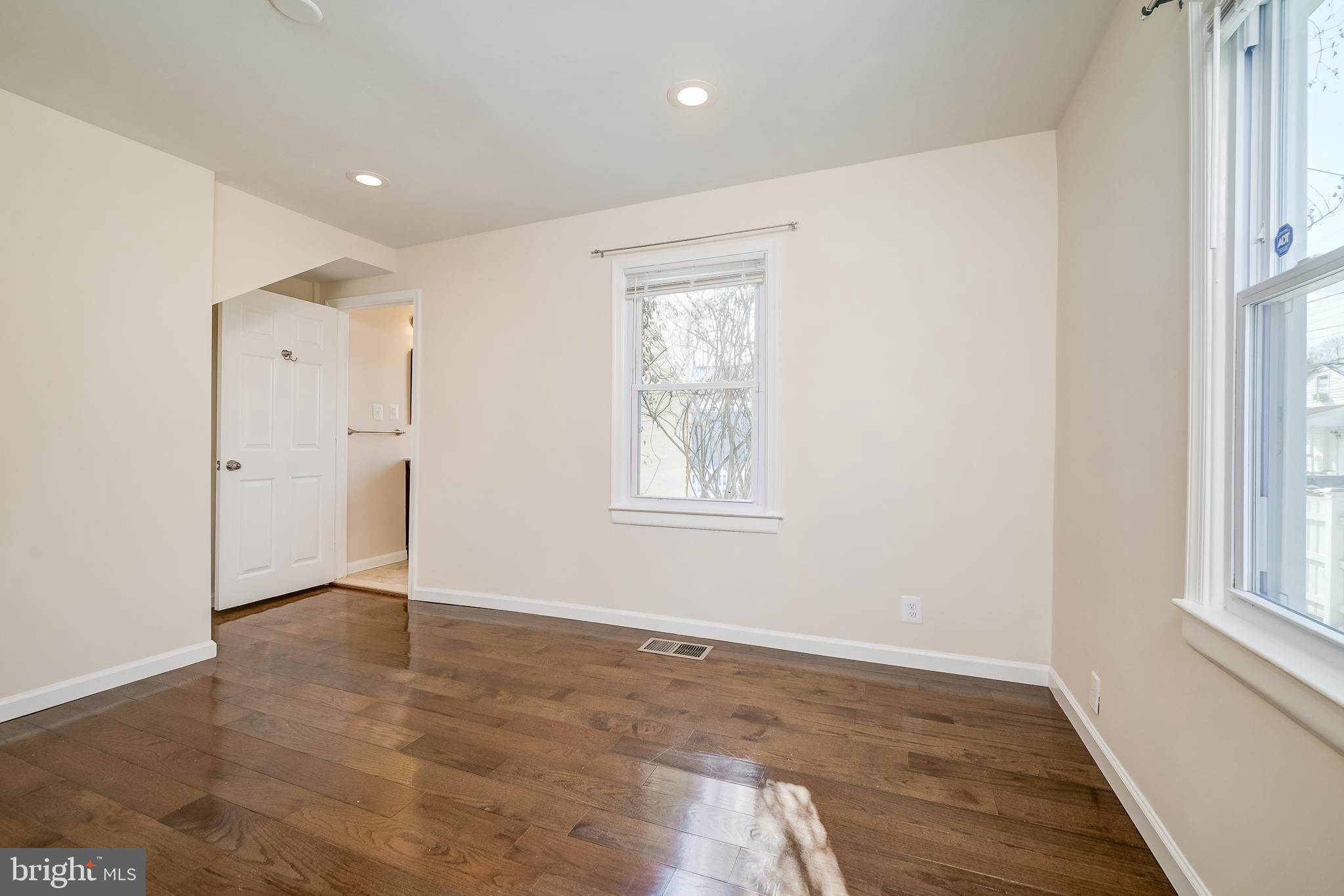 816 Maple Avenue Laurel, MD 20707 - Photo 22 of 45 an empty room with wooden floor and windows