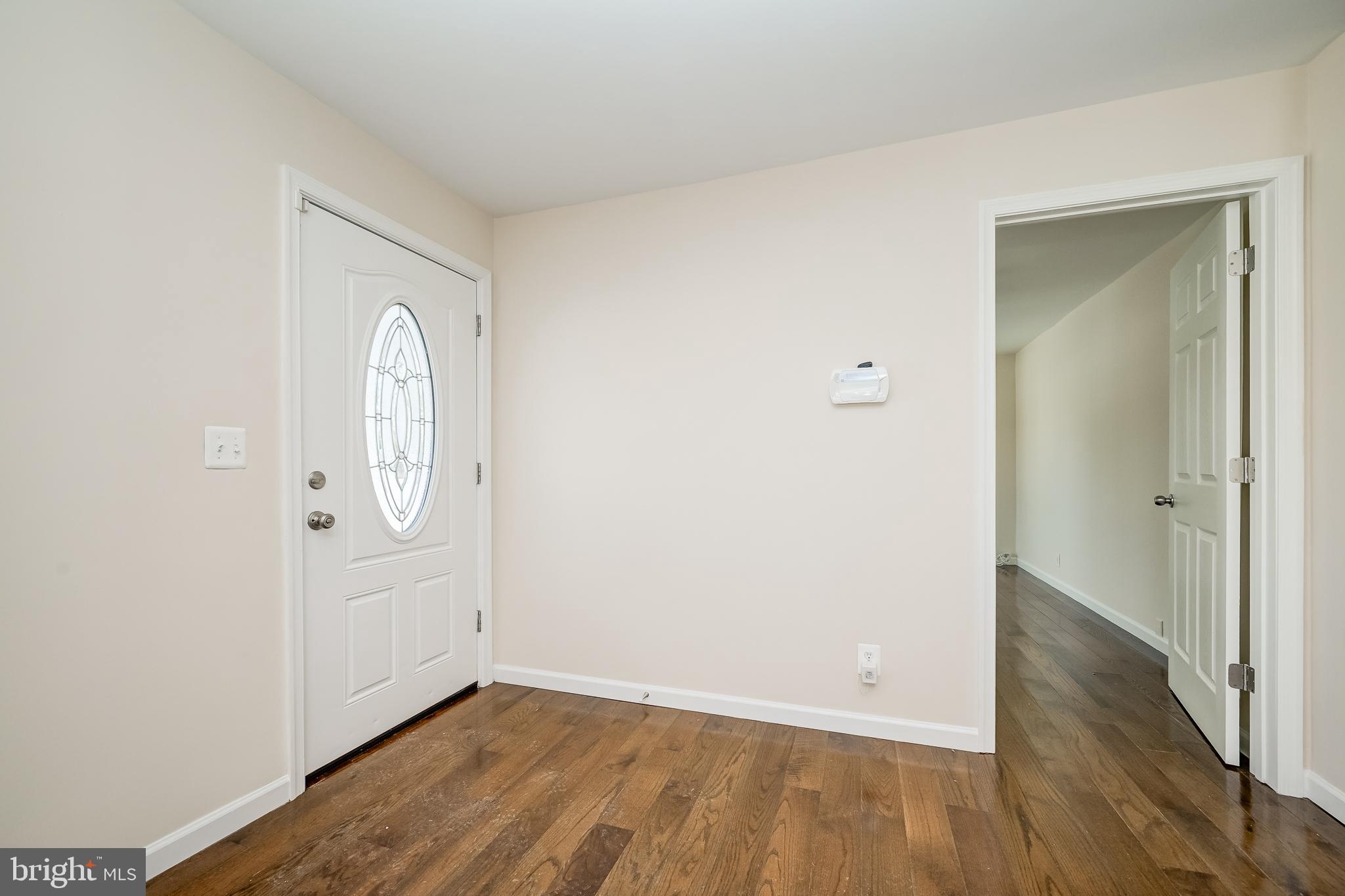 816 Maple Avenue Laurel, MD 20707 - Photo 4 of 45 an empty room with wooden floor and white doors