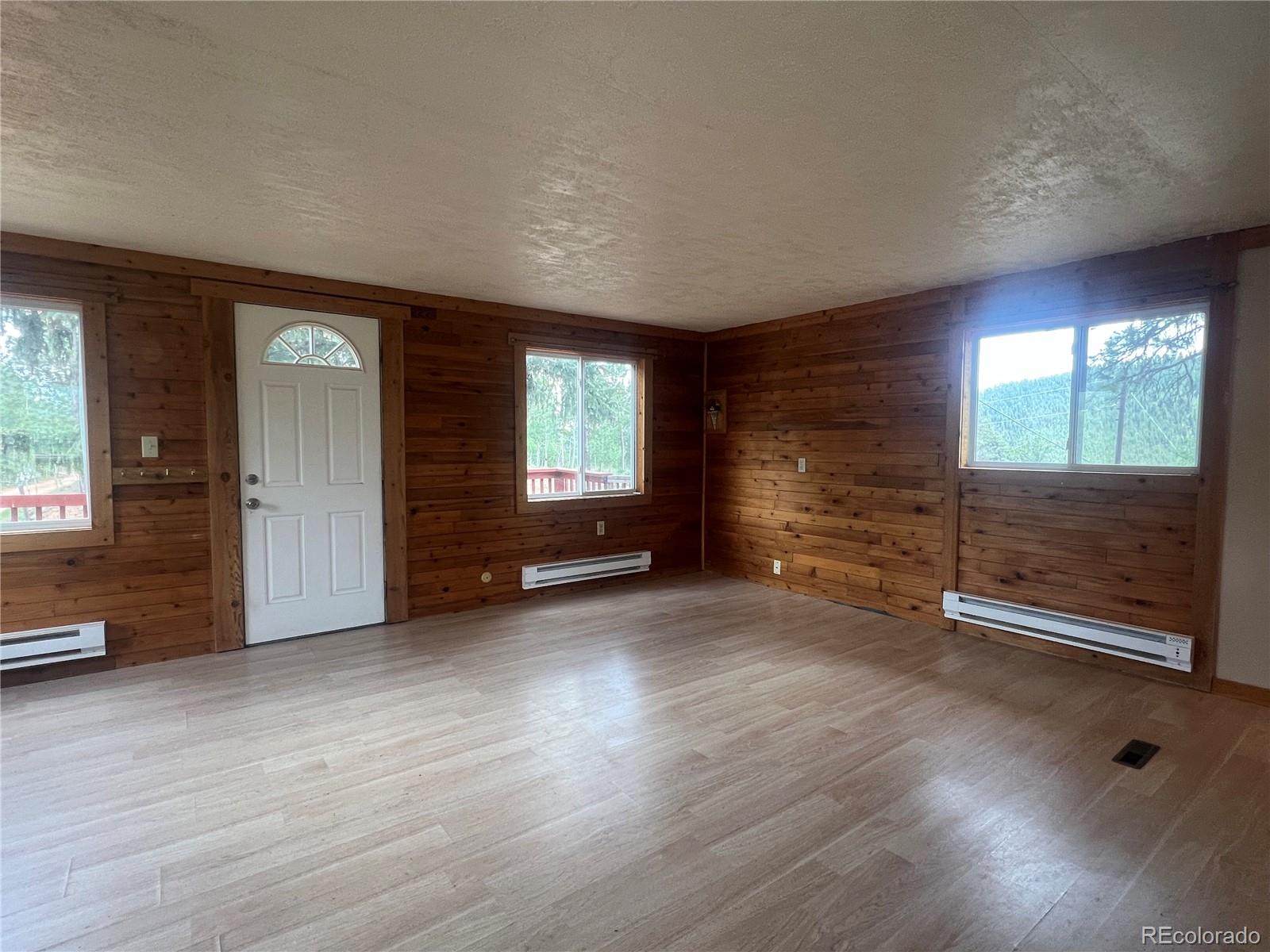 95 Appleby Street Bailey, CO 80421 - Photo 4 of 36 an empty room with wooden floor and windows