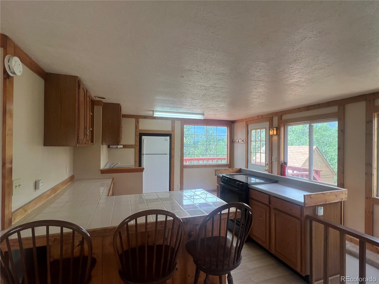 95 Appleby Street Bailey, CO 80421 - Photo 5 of 36 a kitchen with stainless steel appliances granite countertop a sink a stove a refrigerator a dining table and chairs with wooden floor