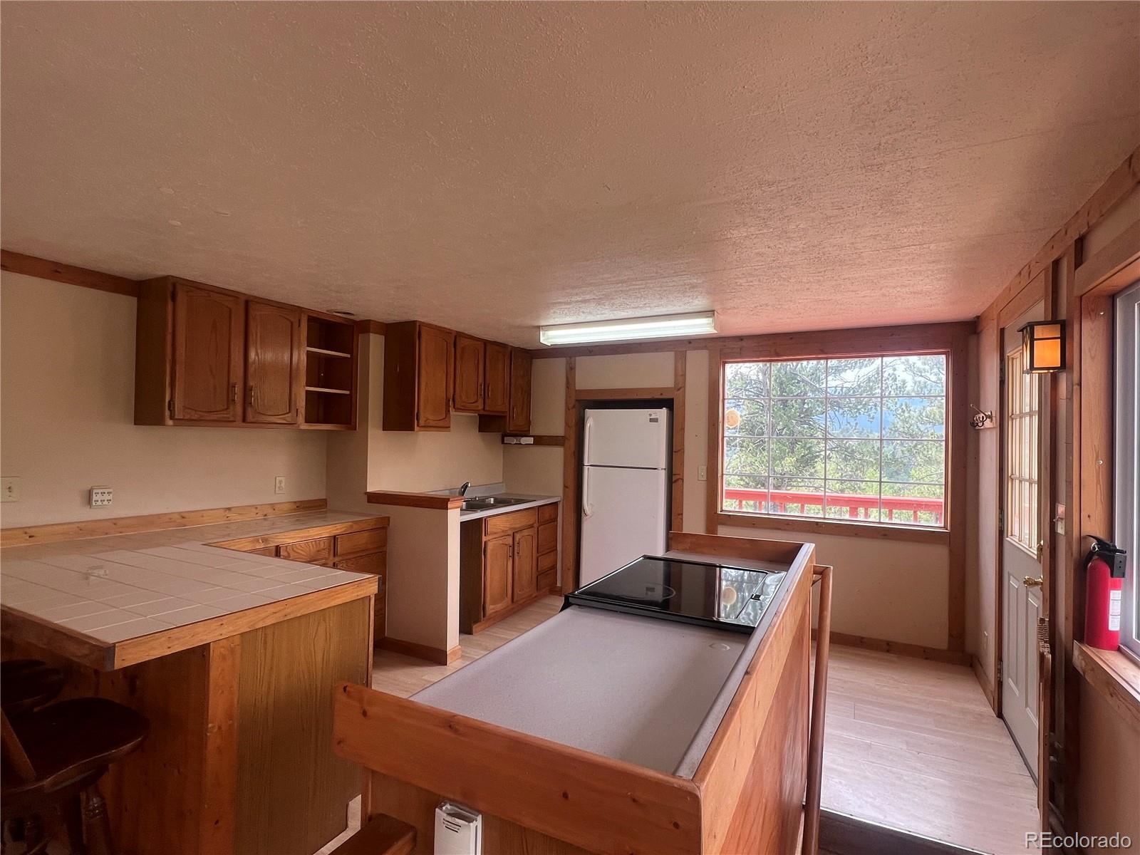 95 Appleby Street Bailey, CO 80421 - Photo 6 of 36 a kitchen with stainless steel appliances a stove top oven a sink dishwasher and a refrigerator with wooden floor
