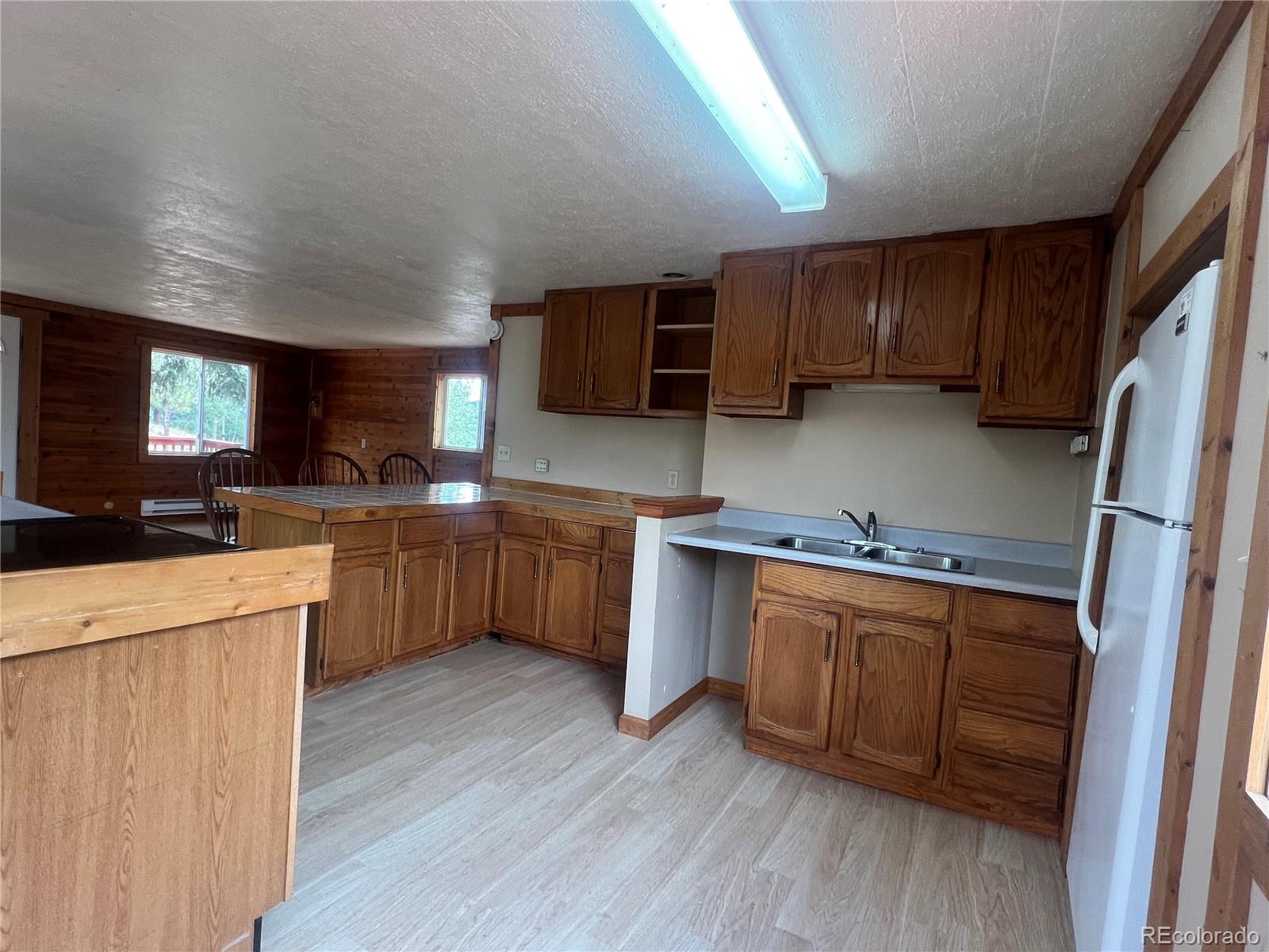 95 Appleby Street Bailey, CO 80421 - Photo 7 of 36 a kitchen with stainless steel appliances a sink cabinets and wooden floor