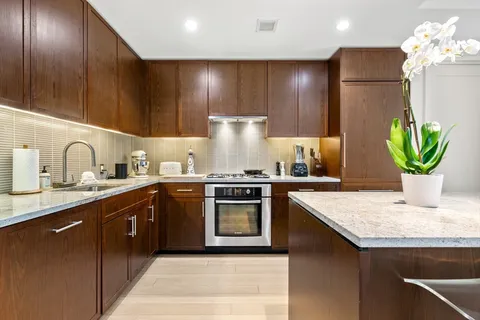 a kitchen with kitchen island granite countertop stainless steel appliances lots of counter top space cabinets and a sink