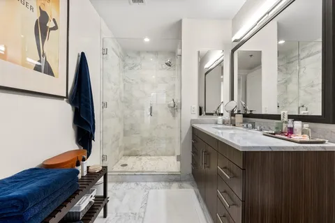 a bathroom with a double vanity sink mirror and shower