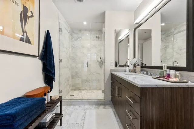a bathroom with a double vanity sink mirror and shower