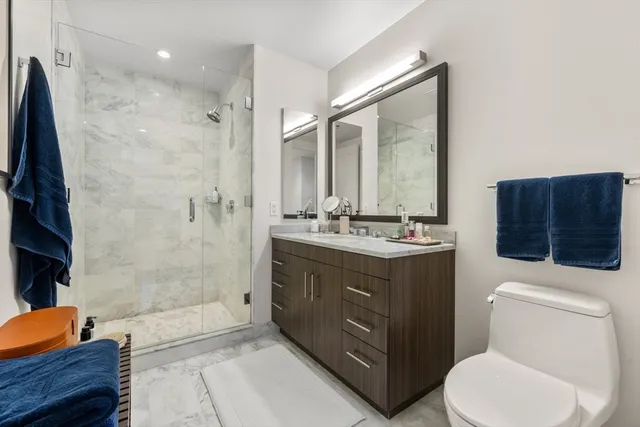 a bathroom with a sink a toilet and shower