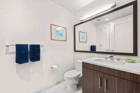 a bathroom with a sink vanity mirror and toilet