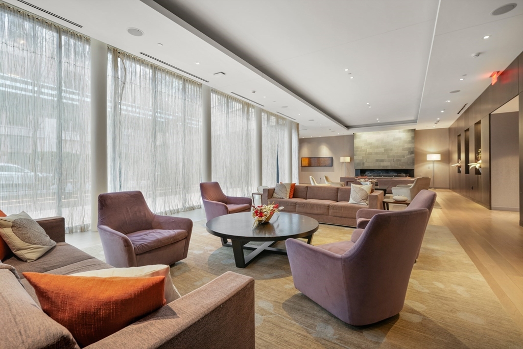580 Washington Street, Unit 611 Boston, MA 02111 - Photo 27 of 39 a living room with furniture and a large window