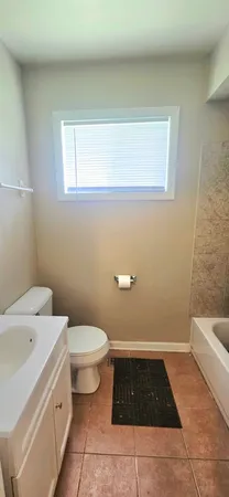 a bathroom with a sink a toilet and a window