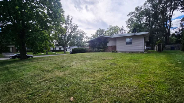 a view of a tree in front of a house with a yard