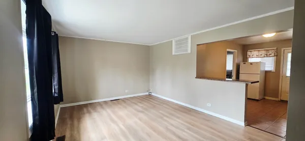 a view of a room with wooden floor and a bathroom
