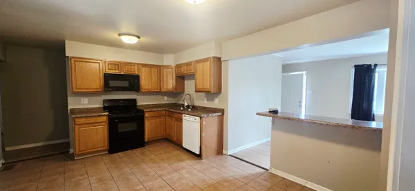 a kitchen with granite countertop a refrigerator and a stove top oven