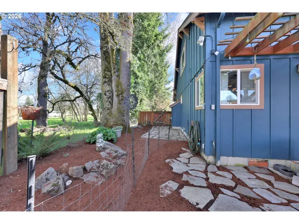 a backyard of a house with a garden and outdoor seating