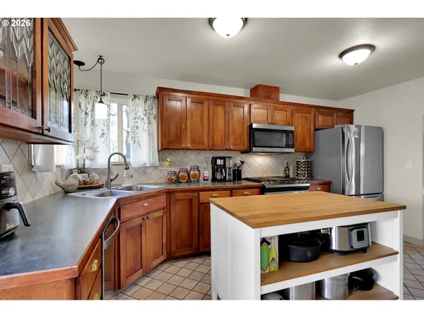 a kitchen with stainless steel appliances a stove a sink a refrigerator and cabinets