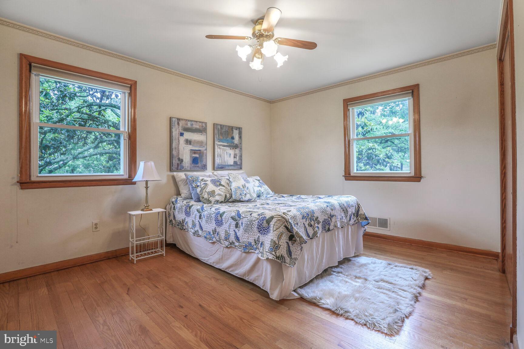 7423 Phelps Road Hanover, MD 21076 - Photo 14 of 28 a bedroom with a large bed chandelier and a window
