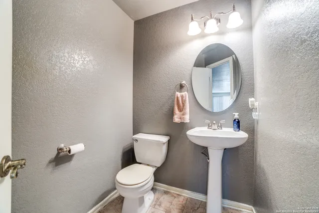 a bathroom with a toilet sink and mirror