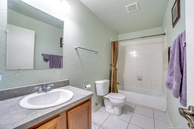 a bathroom with a sink a toilet and a large mirror