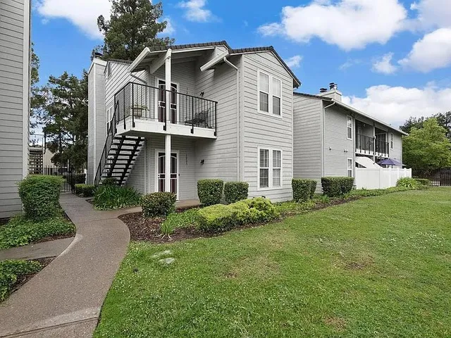 a front view of a house with a yard and trees
