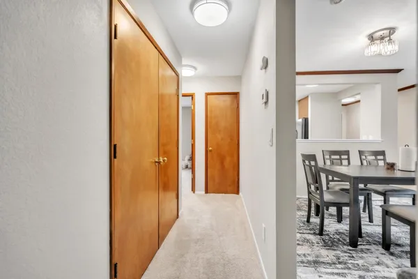 a view of a hallway with furniture and a dining room