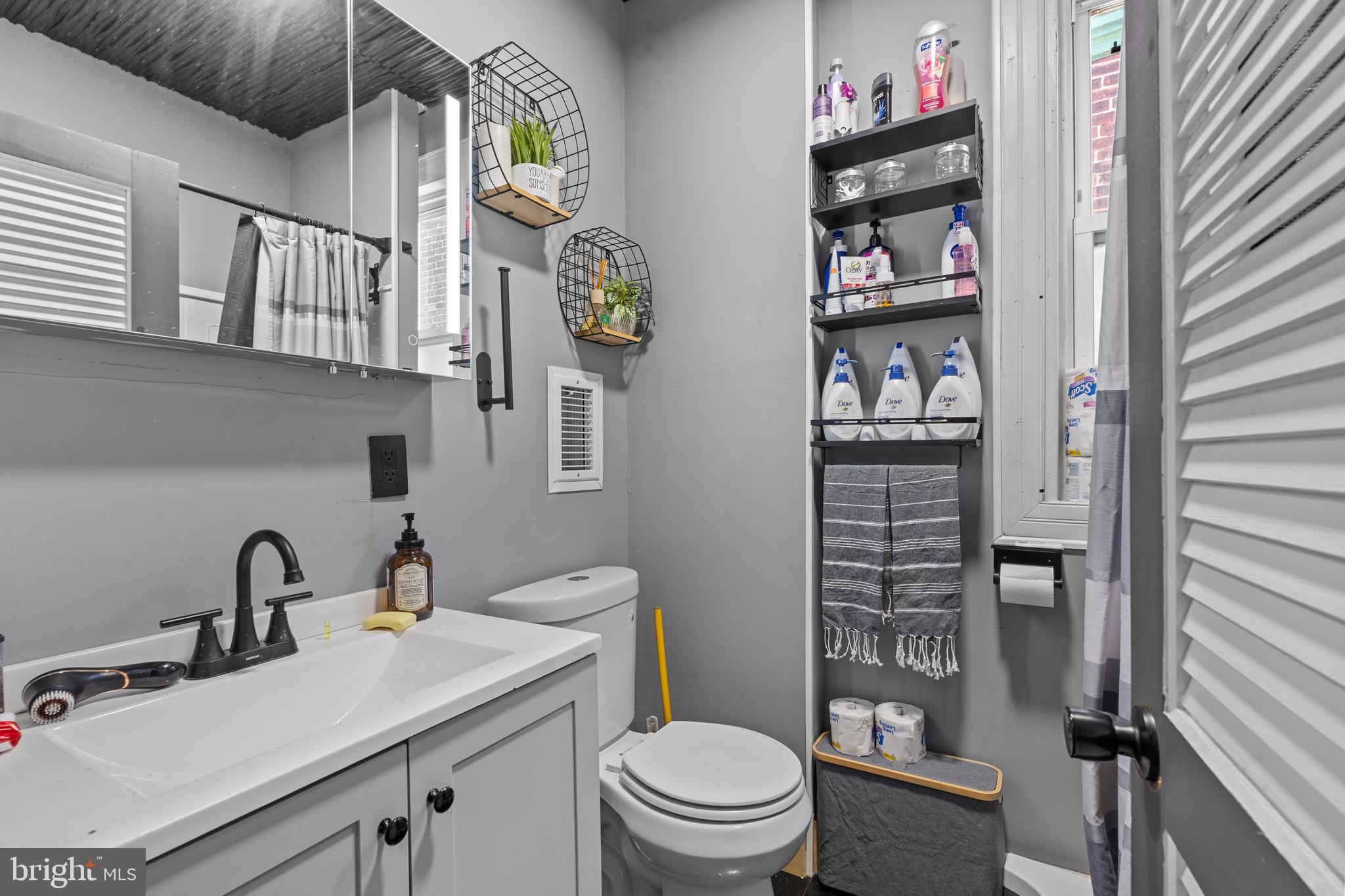 5129 Keyser Street Philadelphia, PA 19144 - Photo 11 of 13 a bathroom with a sink a toilet and a shower curtain