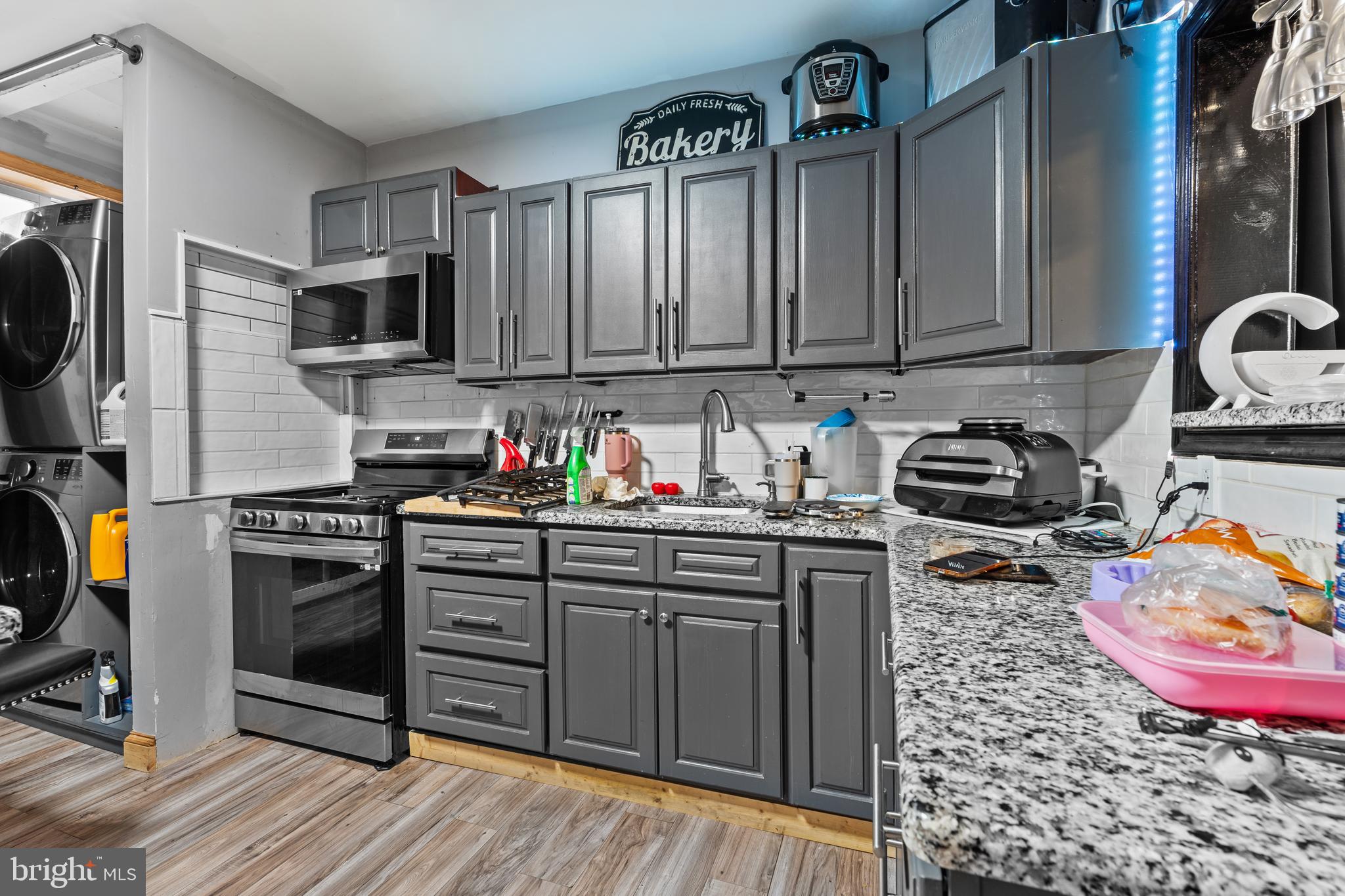 5129 Keyser Street Philadelphia, PA 19144 - Photo 7 of 13 a kitchen with stainless steel appliances granite countertop a stove top oven a sink dishwasher and cabinets with wooden floor