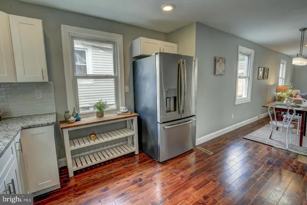 a kitchen with kitchen island wooden floors appliances and cabinets