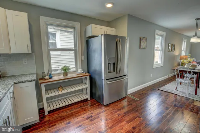 a kitchen with kitchen island wooden floors appliances and cabinets