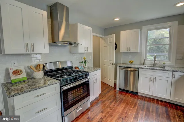 a kitchen with stainless steel appliances white cabinets and a stove