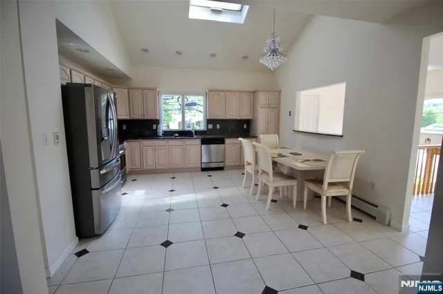 a kitchen with stainless steel appliances kitchen island granite countertop a refrigerator and a stove top oven